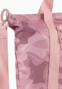 Sac en tissu rose avec un motif camouflage brillant, présentant des textures douces, une sangle réglable et un haut zippé. Comprend un clip en plastique pour fixation.
