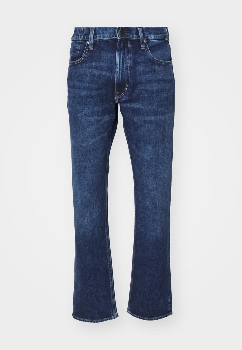 Jeans de mezclilla azul oscuro con campana en el bajo. Las características incluyen un diseño de cinco bolsillos, costuras en contraste y una cierre de botón.