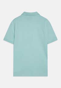 Světle modrá polokošile s krátkým rukávem, límečkem a hladkým bavlněným materiálem. Zadní pohled odhaluje čistý, minimalistický design.