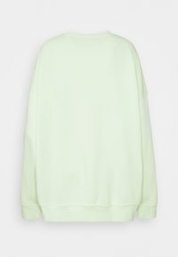 Světle zelená oversized mikina s kulatým výstřihem, dlouhými rukávy a ribkovanými manžetami. Hladká tkanina bez vzorů nebo viditelného kování.