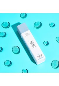 White rectangular bottle with light blue cap; labeled 'B-Hydra Intensive Hydration Serum.' Surrounded by clear gel-like droplets on bright blue background.