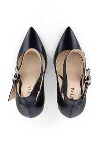 Scarpe alte in pelle nera con punta affusolata, dotate di una cinghia alla caviglia e dettaglio con fibbia. Texture liscia con un interno beige.