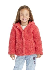 Giacca in pile di un luminoso corallo con cappuccio; presenta un esterno morbido e texture, chiusura a scatto; abbinata a jeans in denim leggero con motivo blu.