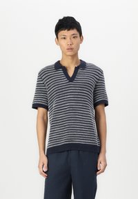 Polo en tricot rayé bleu marine et blanc avec un col en V et des manches courtes. Présente un col et un ourlet côtelés, offrant un aspect texturé.