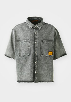 Gray short-sleeved denim shirt with two front pockets, silver buttons, and a frayed hem. Features a small orange label on the pocket.