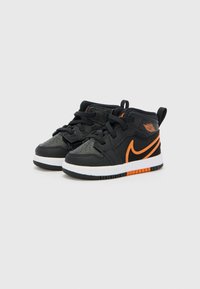 Sneakers alte neri e arancioni con una superficie in pelle texturizzata, suola intermedia bianca e dettagli arancioni a contrasto sui lati e sul logo.