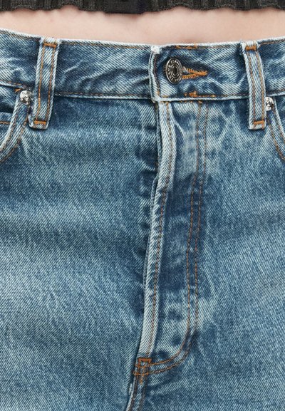 Jeans en denim bleu clair avec taille haute, coutures orange contrastantes, fermeture à bouton et une légère texture délavée.