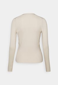 Beige ribbad långärmad tröja sedd bakifrån med rund halsringning och figurnära passform.