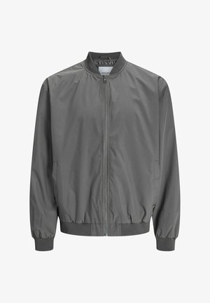 Harmaa pommikauppiasmateriaalia, joka on valmistettu liukkaasta, kevyestä materiaalista, jossa on koko pituinen vetoketju edessä, ribbed hihansuut ja tiukasti istuva vyötärö. Yksinkertainen muotoilu ilman kuvioita.