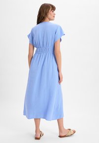 Light blue, ankle-length dress made of textured fabric, featuring a cinched waist and short flutter sleeves. Simple design, no patterns.