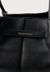 Crna kožna torbica s glatkom teksturom, nabranom izradom i zlatnim "Valentino" logotipom na horizontalnom remenu.