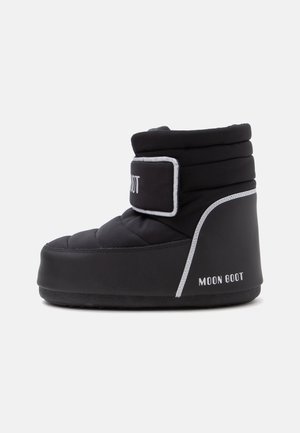 Μαύρο μονωμένο Moon Boot με επενδεδυμένο επάνω μέρος, λουράκι με βέλκρο, λευκή φάσα και επίπεδη καουτσούκ σόλα, εμφανίζεται πλαγίως σε λευκό φόντο.