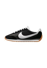 Baskets noires en daim et nylon avec logo swoosh blanc, présentant un design bas, un laçage plat et une semelle extérieure en caoutchouc naturel.