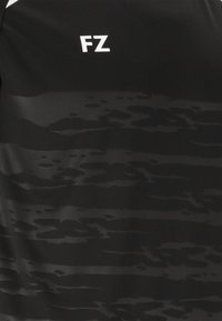 Svart träningsskjorta med en subtil texturerad mönstring. Har en vit "FZ"-logotyp på den övre vänstra sidan. Tillverkad av ett mjukt, lätt material.