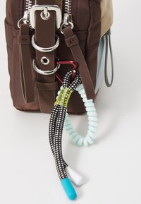 Borsa in tessuto marrone con hardware argento, caratterizzata da accenti in tessuto colorato, corda nera e bianca texturizzata e un dettaglio arrotolato verde menta.