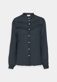 Blusa blu scuro realizzata in tessuto testurizzato con un motivo a pois. Presenta un colletto rotondo, chiusura con bottoni e dettagli arricciati sulla parte anteriore.