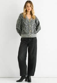 Gray cardigan with black leopard print, V-neck, and five gold buttons at the front. Paired with black jeans and ankle boots.