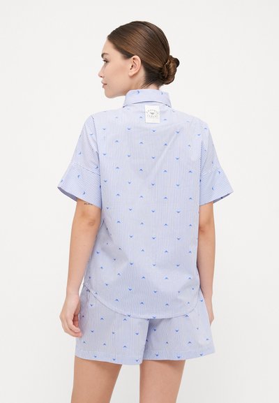 Conjunto de pijama de manga corta en rayas azul y blanco, con pequeños patrones de anclas azules. Tejido ligero con un ajuste relajado.