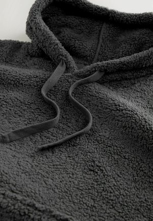 Grå fleece hættetrøje med en tekstureret overflade, bred hætte og snore. Blødt materiale, der har et hyggeligt og varmt design.