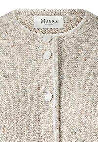 Beige strukturierter Strickcardigan mit einem runden Ausschnitt, fünf silbernen Knöpfen und einem Markenetikett, das im Kragen eingenäht ist.