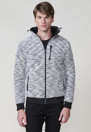 Chaqueta con capucha en tejido texturizado gris y negro, con cremallera completa, bolsillos laterales y puños y dobladillo elásticos. Presenta un logo en la cremallera.