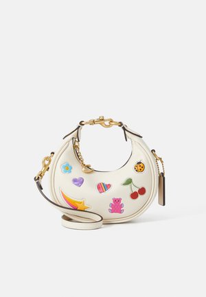 Cremfarbener Lederhandtasche mit einer geschwungenen Form, die farbenfrohe, verspielte Patches, goldene Beschläge und einen abnehmbaren Schulterriemen aufweist.