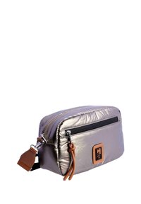 Necessaire cosmético metálico plateado de forma rectangular, con un zipper negro y acentos de cuero marrón. Textura suave y brillante en toda su superficie.