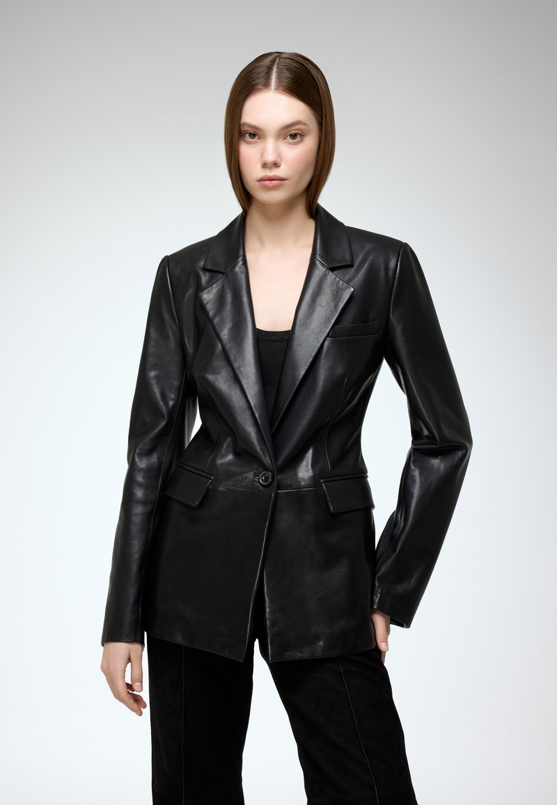 Black leather blazer with a tailored fit, notched lapels, single button closure, and side pockets. Smooth texture and shiny finish.