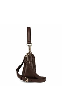 Borsa a tracolla in pelle di colore marrone scuro vista di lato, con tracolla regolabile, anello per il polso e accessori in metallo argentato su sfondo bianco.