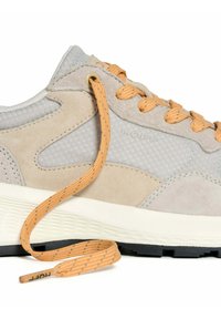 Lichtgrijze en beige sneaker met oranje veters, gestructureerde zool en "HOFF" merknaam aan de zijkant, gefotografeerd op een witte achtergrond.