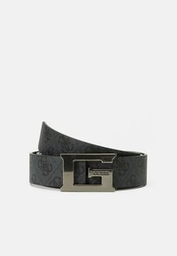 Ceinture noire à motif fabriquée en matériau synthétique, dotée d'une boucle en métal argenté en forme de G avec le nom de la marque "Guess" embossé dessus.