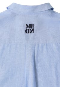 Dos de chemise bleu clair avec un col cousu et un texte brodé noir "MIDN STEADY" près du cou.