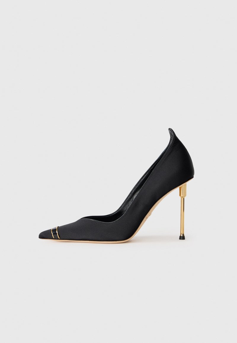 Black satin high-heeled pump with a pointed toe, featuring gold-tone hardware accents on the vamp and a metallic gold stiletto heel.