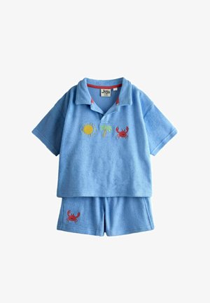 Jasnoniebieski strój dla malucha z krótkimi rękawami i krótkimi spodenkami, z haftowanymi wzorami słońca, palmy i czerwonego kraba na koszulce oraz wzorem kraba na spodenkach.