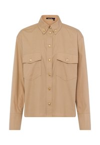 Beige button-up shirt with a collar, long sleeves, and two chest pockets. Features gold buttons and a smooth cotton texture.