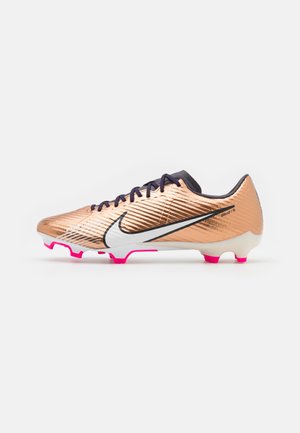 Metallic copper soccer cleat with black laces, white Nike swoosh, and pink studs on a white sole against a plain background.