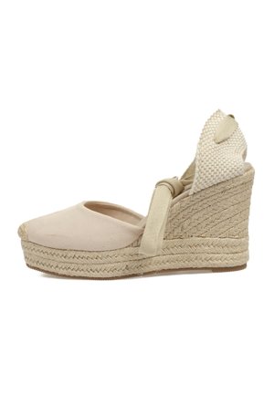 Wedge de esparto beige con puntera cerrada, parte superior de lona y suela de yute trenzado. Presenta un tacón trenzado y una suave tira de tobillo para un ajuste seguro.