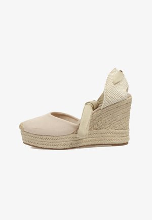 Wedge de esparto beige con puntera cerrada, parte superior de lona y suela de yute trenzado. Presenta un tacón trenzado y una suave tira de tobillo para un ajuste seguro.