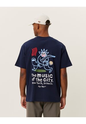 Mørkeblå bomulds t-shirt med et farverigt grafisk design på ryggen, der har teksten "Byens musik" og legesyge karakterillustrationer.