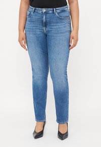 Light blue denim jeans with a slim fit, five pockets, and a subtle embellishment on the front pocket. Smooth texture with standard waistband.