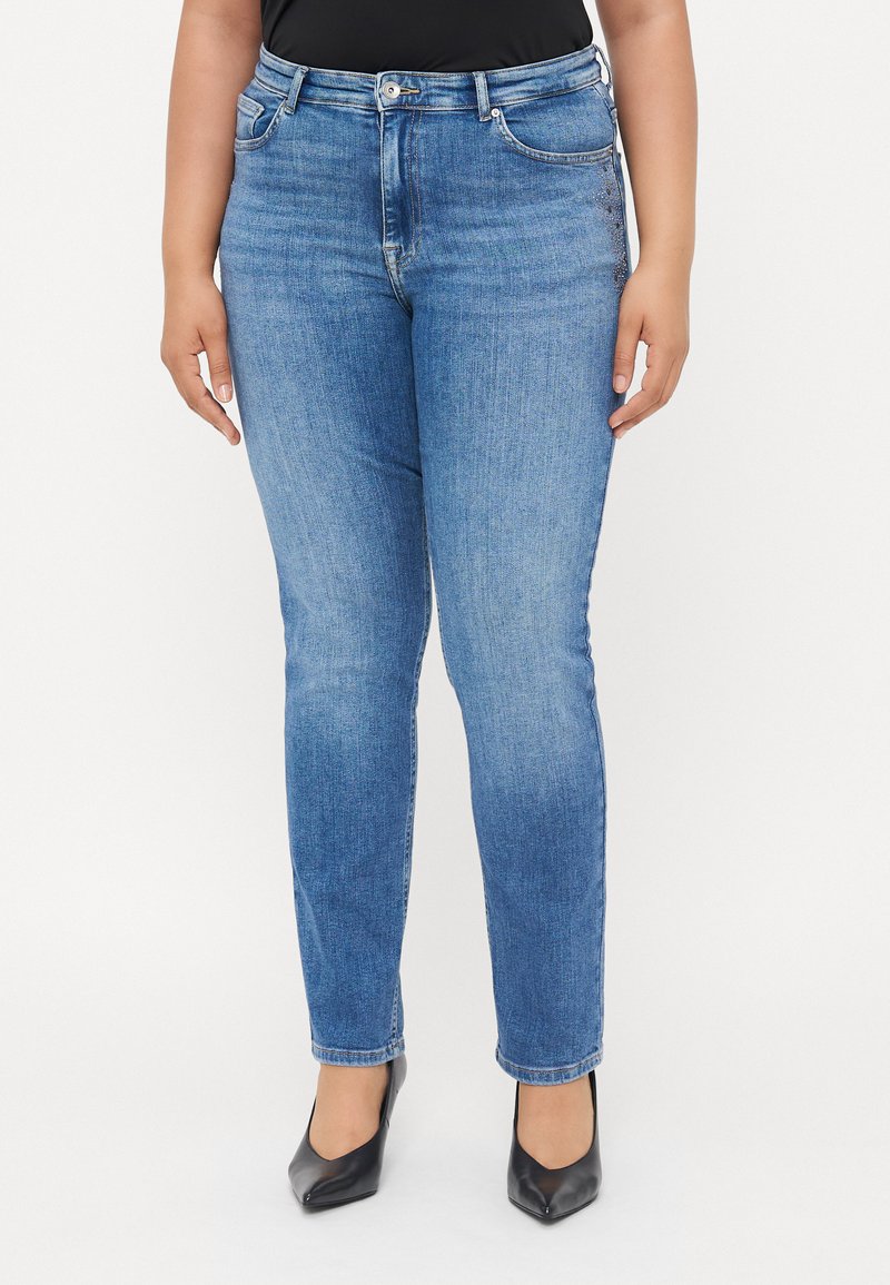 Light blue denim jeans with a slim fit, five pockets, and a subtle embellishment on the front pocket. Smooth texture with standard waistband.