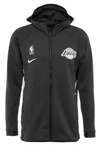 Sort lynlåse hættetrøje med struktureret stof, med NBA-logoet og Los Angeles Lakers emblem. Har en hætte og hvide sideakcenter.