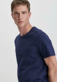 Navyblaues Baumwoll-T-Shirt mit kurzen Ärmeln, Rundhalsausschnitt und glatter Textur, mit minimalistischen Nähten und regulärer Passform.