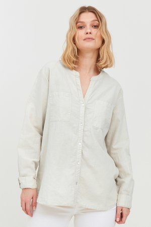 Helle beige Button-up-Hemden mit Kragen, zwei Brusttaschen, langen Ärmeln und einer lockeren Passform. Aus leichtem Stoff mit einer subtilen Textur gefertigt.
