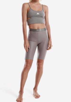 Completo sportivo grigio composto da un top a fascia corto con aperture e pantaloni corti a vita alta abbinati, realizzati in tessuto elastico e morbido.