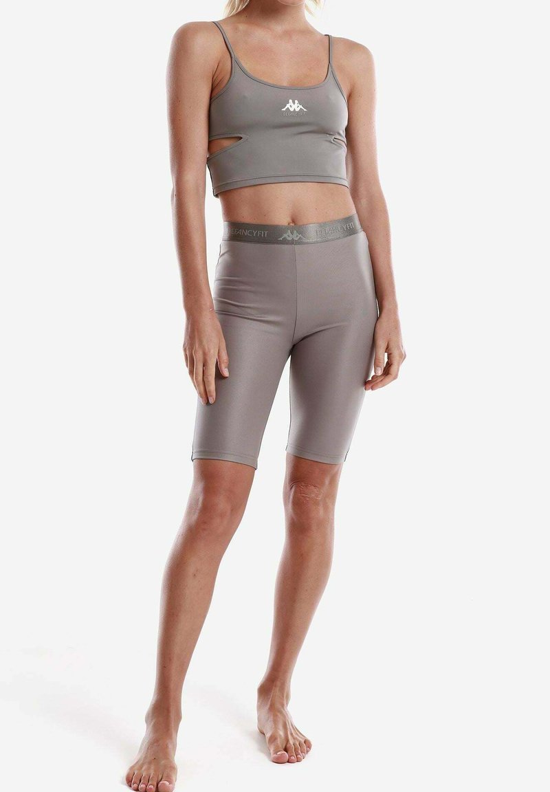 Completo sportivo grigio composto da un top a fascia corto con aperture e pantaloni corti a vita alta abbinati, realizzati in tessuto elastico e morbido.