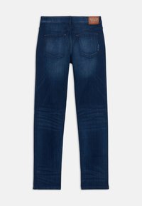 Donker gewassen denim jeans met een getailleerd ontwerp, voorzien van twee achterzakken en een leren merklabel op de taille. Gladde textuur, rechte pijp.