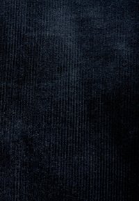 Textil moale de culoare albastru închis, cu o textură canelată. Suprafața pare moale și ușor lucioasă, conferind adâncime vizuală.