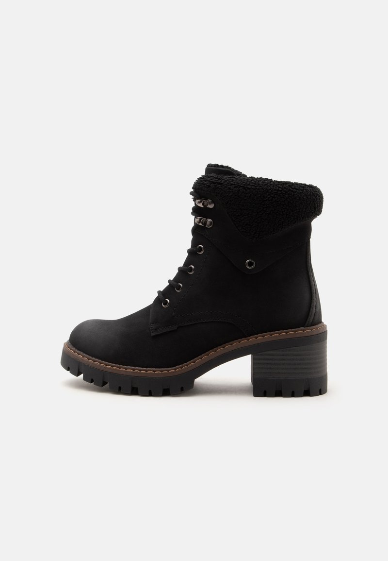 Bottine noire à lacets avec talon épais, revers en peau lainée et semelle robuste, présentée de profil sur un fond uni.