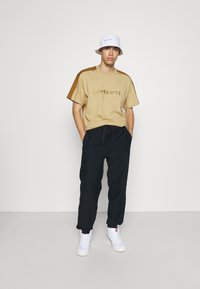 Carhartt WIP AMERICAN SCRIPT PANT - Calças de fato de treino - astro